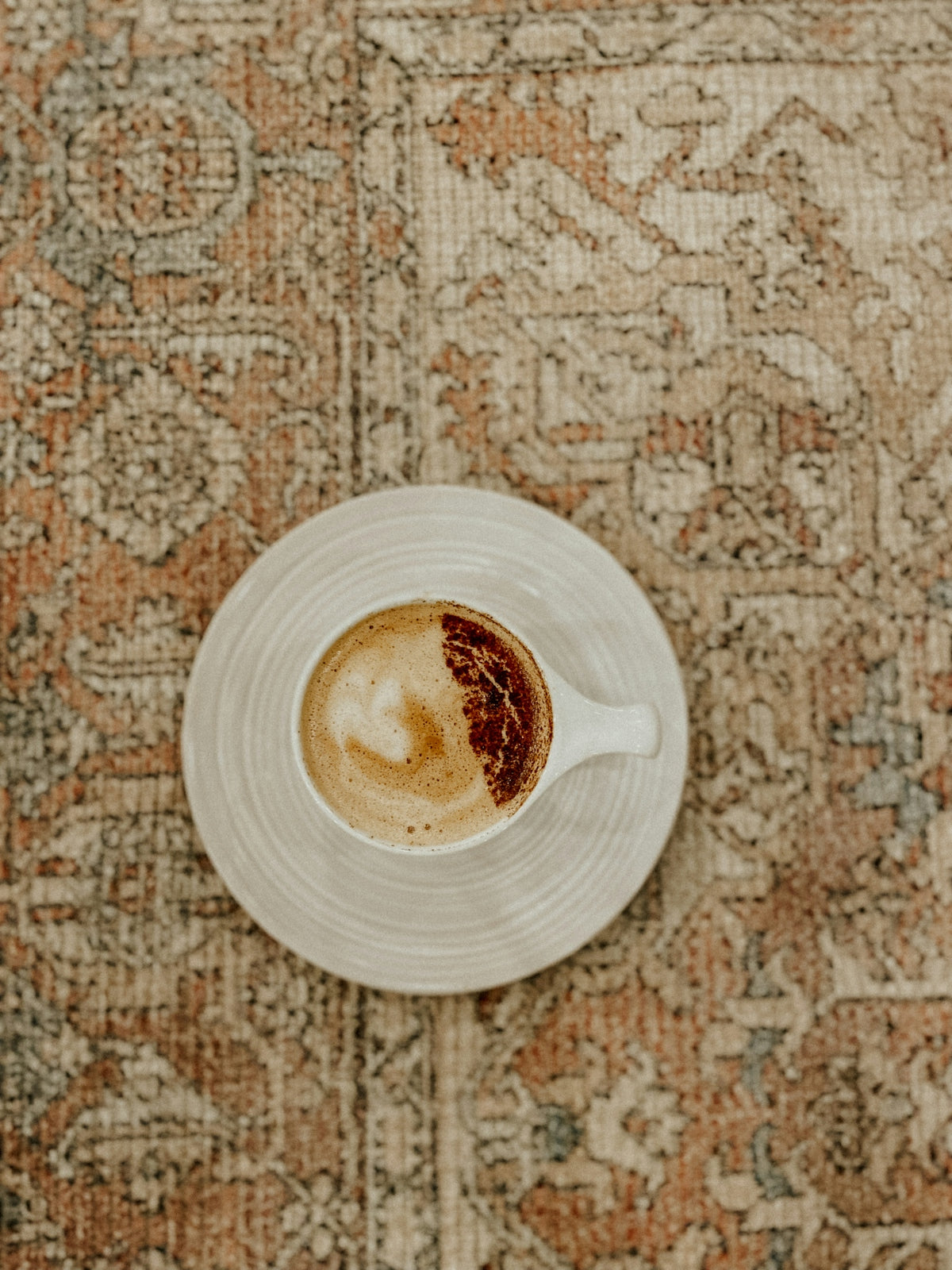 a cup of coffee sitting on top of a white saucer